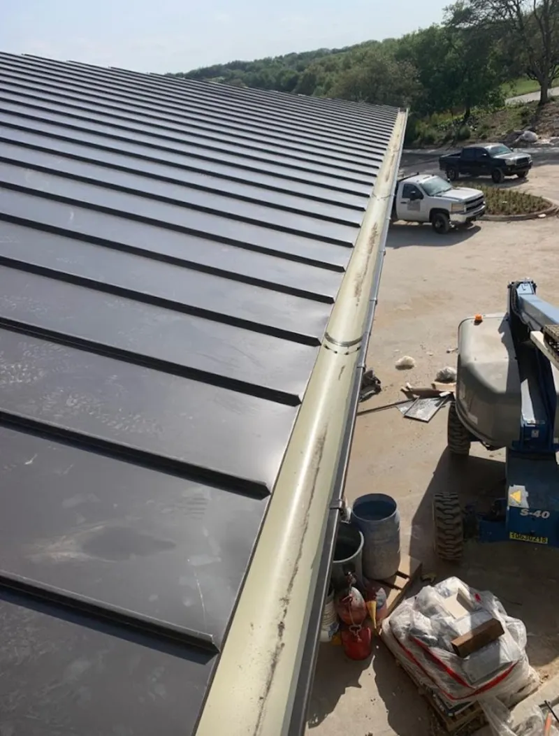 Standing seam panel and gutter detail on a metal roofing jobsite in Perryville
